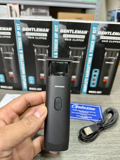 Gentleman professional hair clipper packaging held by a hand with additional products in the background.