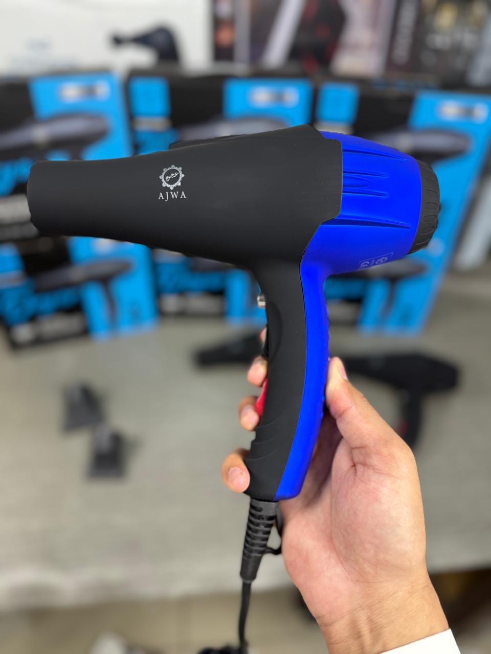 Hand holding a blue and ajwa hair dryer in black and blue finish.
